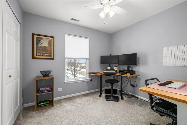 a view of a workspace with furniture and a window