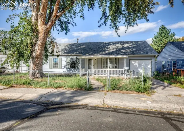a view of house in front of a yard with potted plants