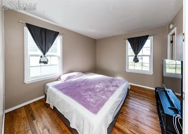 a bedroom with a bed and a flat tv screen on a dresser