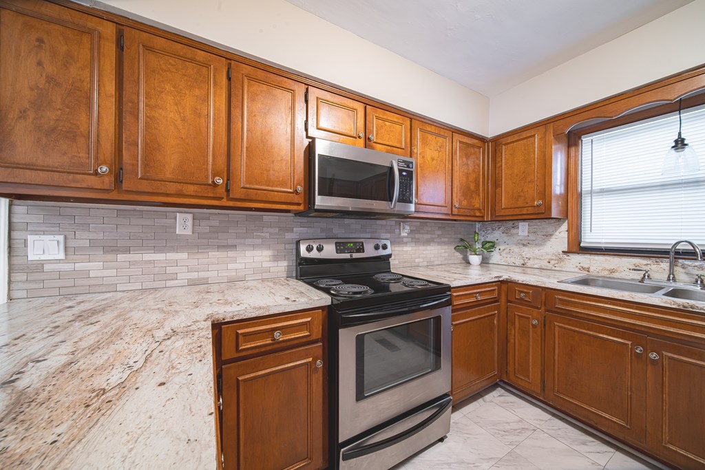3009 Plantation Road Columbus, GA 31903 - Photo 8 of 13 a kitchen with granite countertop a sink stove and microwave