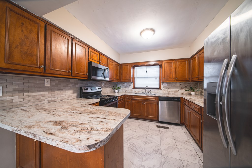 3009 Plantation Road Columbus, GA 31903 - Photo 9 of 13 a kitchen with stainless steel appliances granite countertop a sink stove microwave and refrigerator