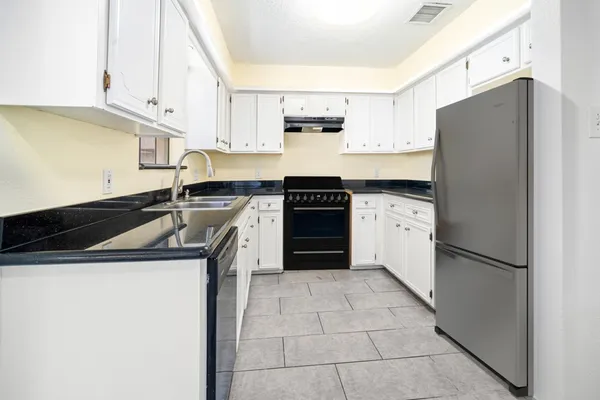 a kitchen with a stove sink and refrigerator