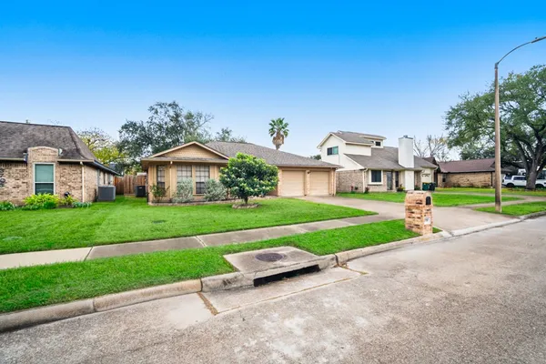a view of a house with a big yard plants and large trees
