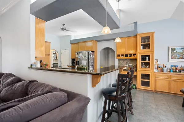 a living room with stainless steel appliances kitchen island granite countertop furniture and a large window