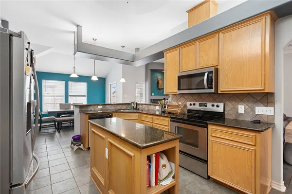 a kitchen with stainless steel appliances a stove a sink and a microwave