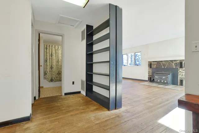 a view of an empty room with a fireplace and a window