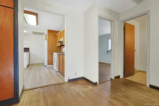 a view of a hallway with wooden floor and a cabinet