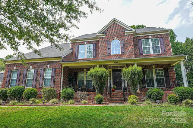 front view of the brick house with a yard