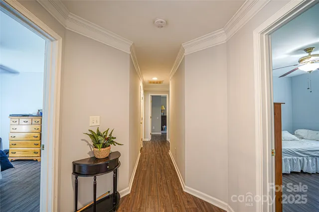 a view of a hallway with dining room and wooden floor