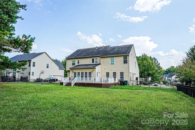 a view of a house with a big yard and large trees