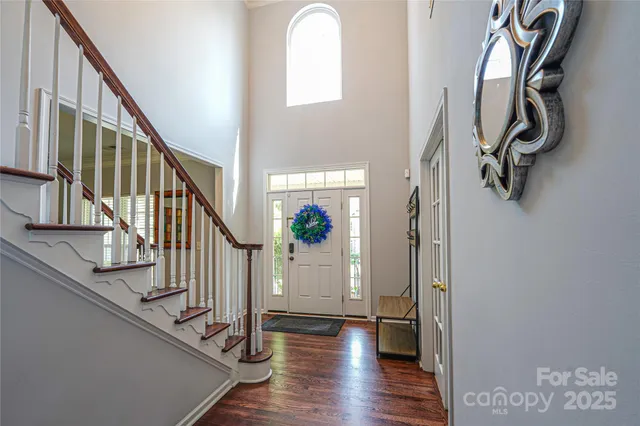 a view of a hallway with wooden floor and staircase