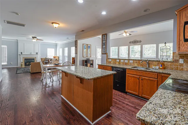 a kitchen with stainless steel appliances granite countertop wooden floors and view