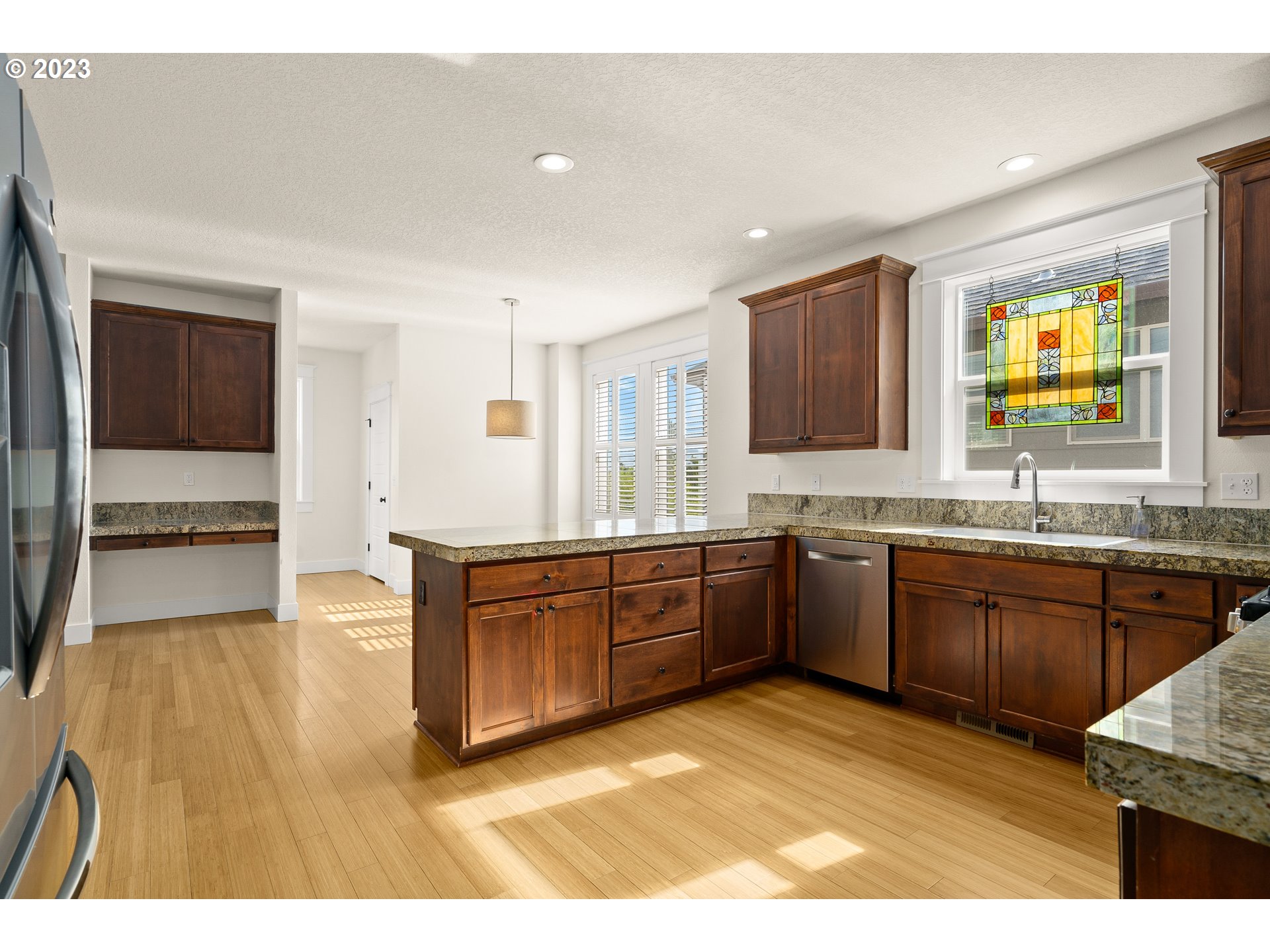 3917 Southwest Stephenson Street Portland, OR 97219 - Photo 13 of 34 a kitchen with stainless steel appliances granite countertop a sink and dishwasher stove with wooden floor