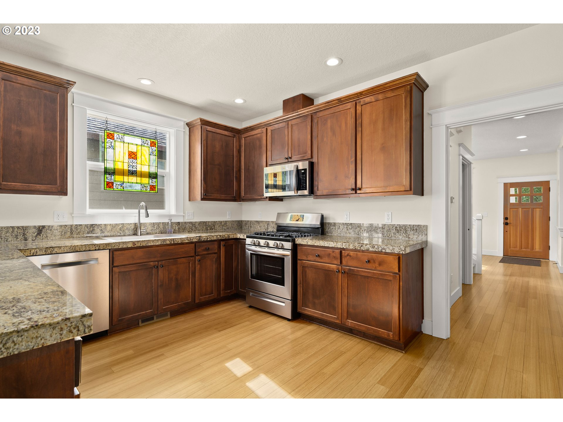 3917 Southwest Stephenson Street Portland, OR 97219 - Photo 14 of 34 a kitchen with stainless steel appliances granite countertop a stove sink and cabinets