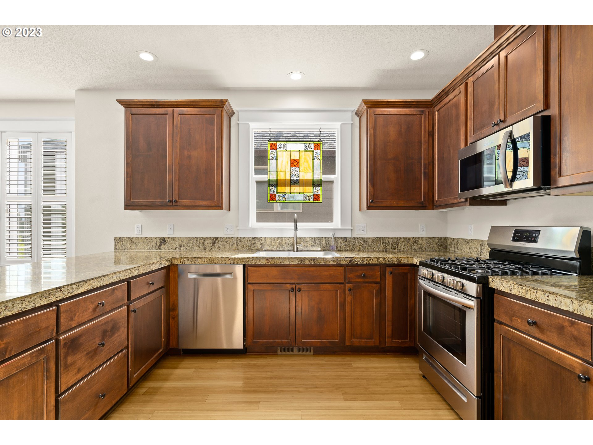 3917 Southwest Stephenson Street Portland, OR 97219 - Photo 15 of 34 a kitchen with stainless steel appliances granite countertop a sink stove and microwave