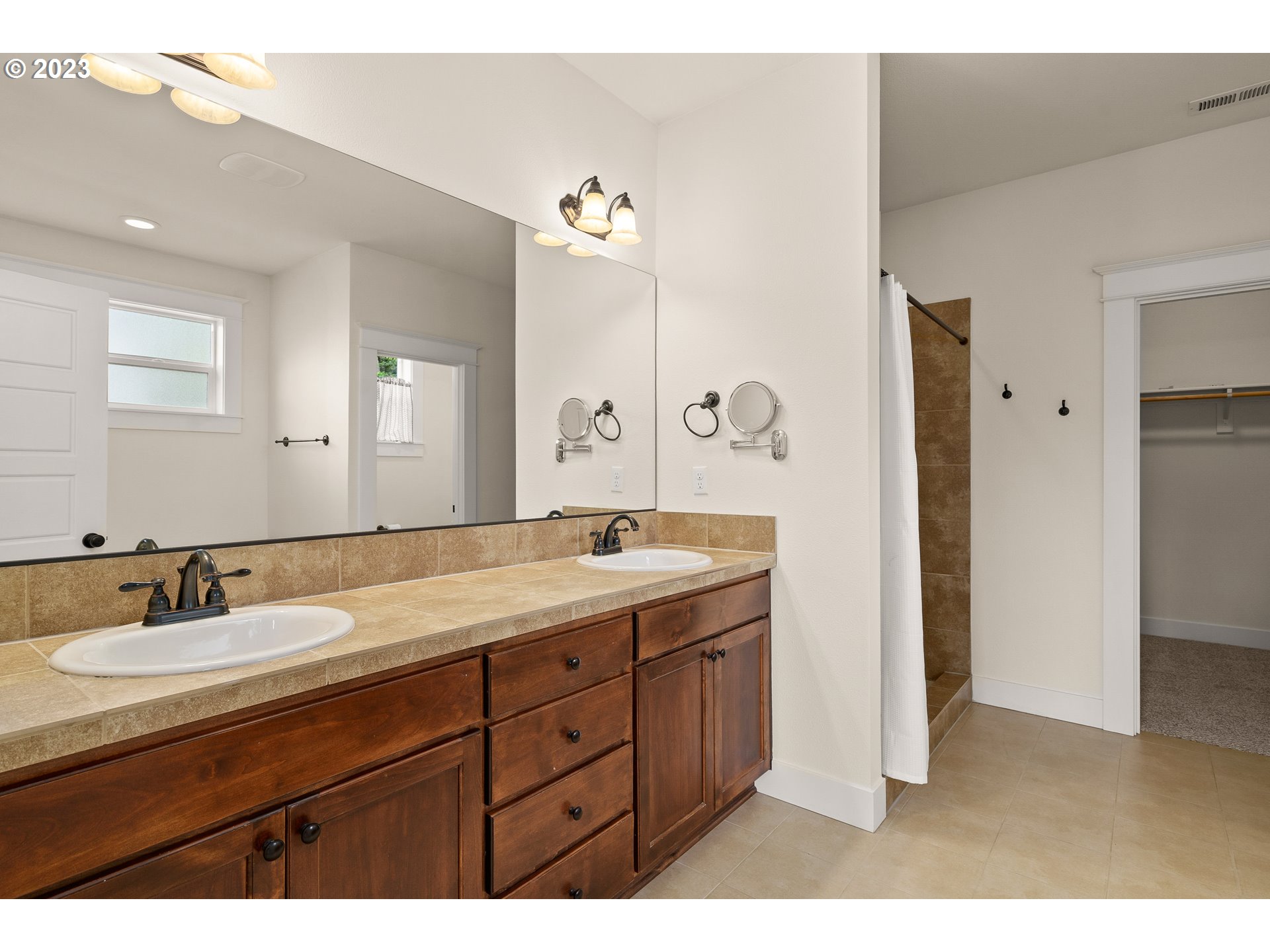 3917 Southwest Stephenson Street Portland, OR 97219 - Photo 21 of 34 a bathroom with a granite countertop sink double and mirror