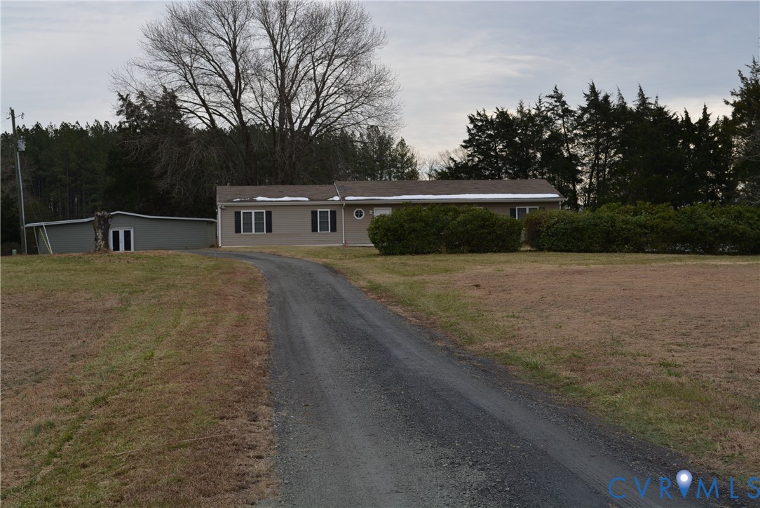 a view of house with yard and trees in the background