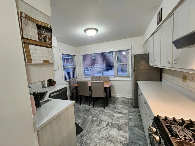 a kitchen with a refrigerator stove and white cabinets