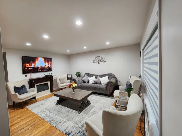 a living room with furniture kitchen view and a large window