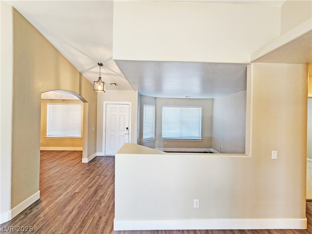 4591 Stoneham Street Pahrump, NV 89061 - Photo 6 of 42 Natural light filters through windows, illuminating rich wood flooring and a flowing interior layout.