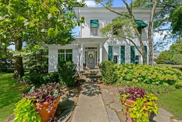 a front view of a house with a garden