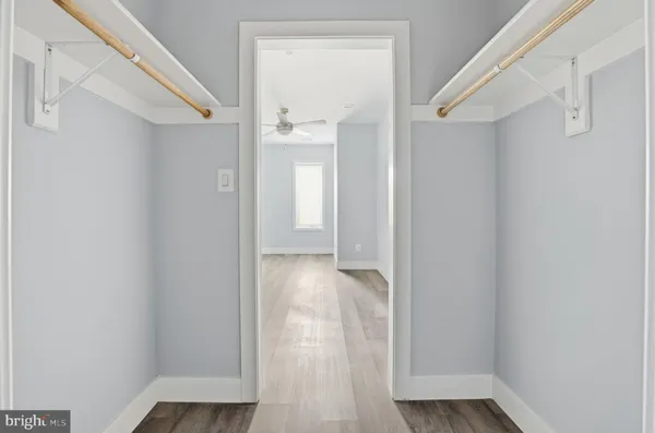 a view of a hallway with wooden floor and closet