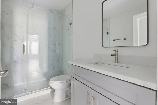a bathroom with a sink a toilet and a mirror
