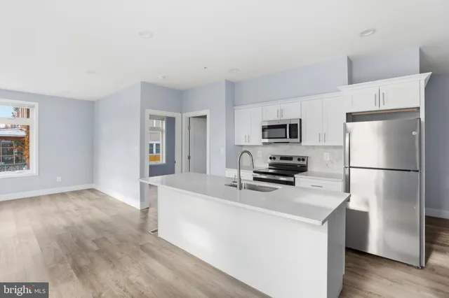 a kitchen with stainless steel appliances a refrigerator stove microwave and sink