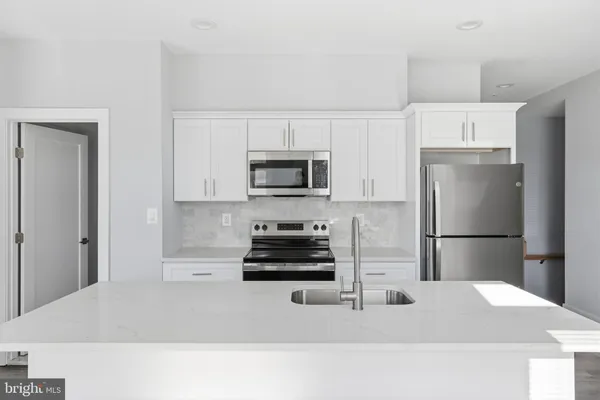 a kitchen with a refrigerator and a stove top oven