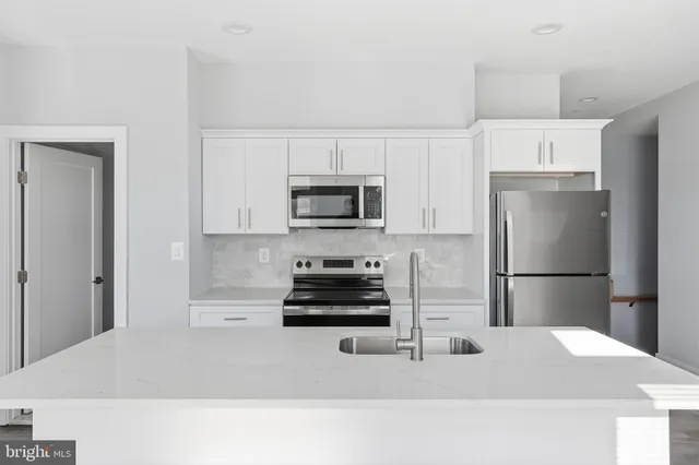 a kitchen with a refrigerator and a stove top oven