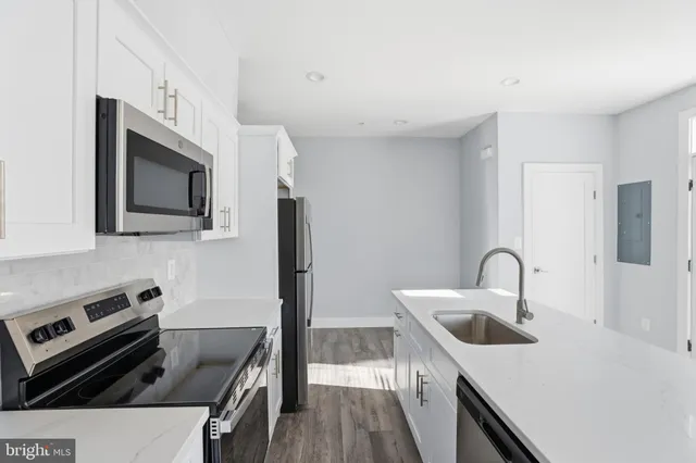 a kitchen with stainless steel appliances a microwave a sink and cabinets