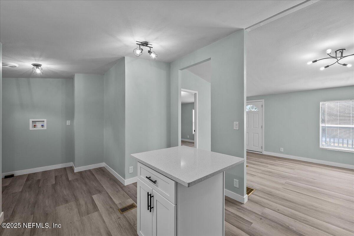 316 Sheila Avenue Interlachen, FL 32148 - Photo 12 of 22 a view of a hallway with wooden floor and chandelier