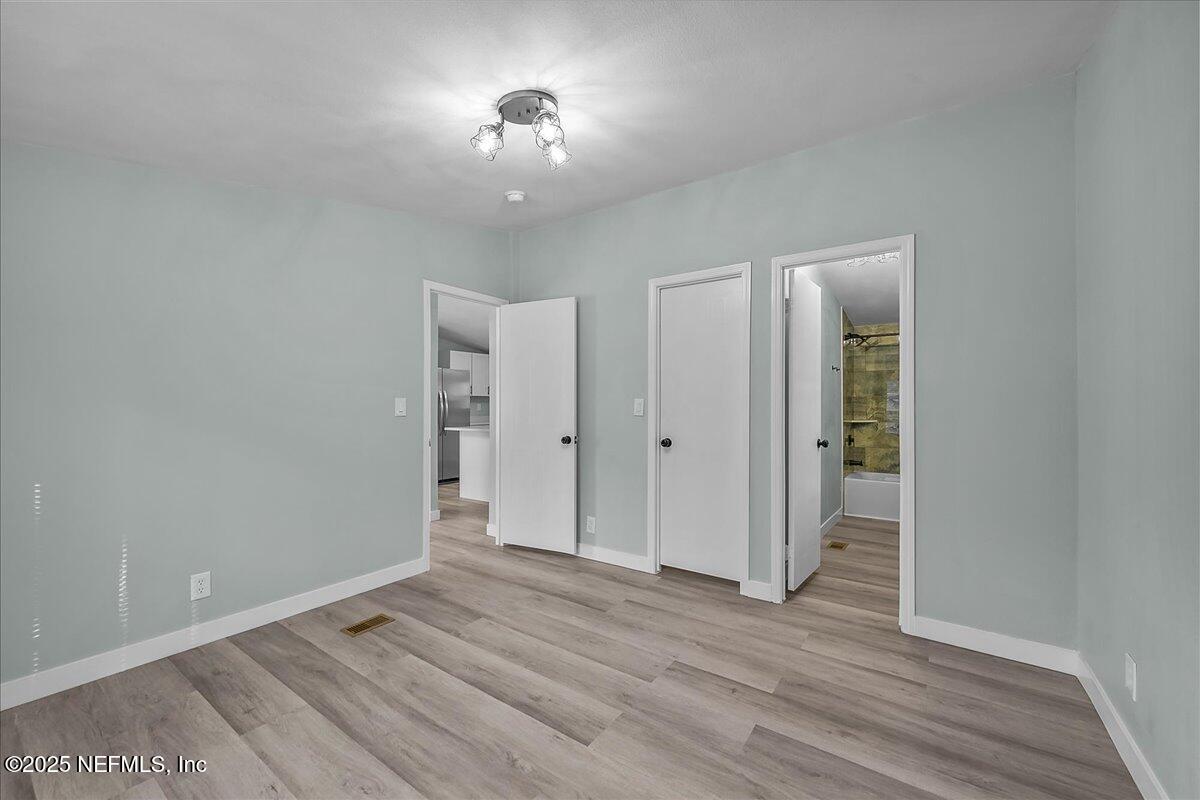 316 Sheila Avenue Interlachen, FL 32148 - Photo 13 of 22 wooden floor in an empty room with a window