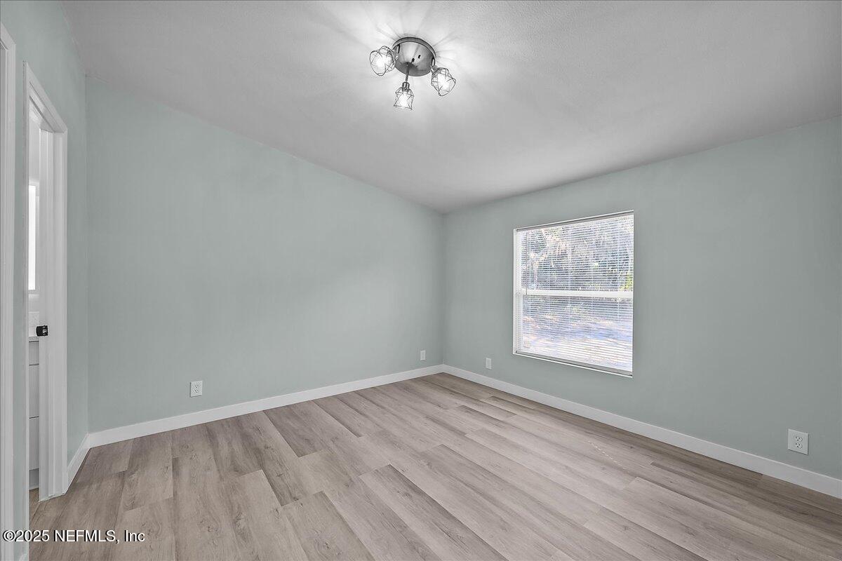 316 Sheila Avenue Interlachen, FL 32148 - Photo 14 of 22 wooden floor in an empty room with a window