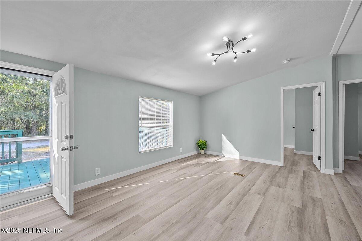 316 Sheila Avenue Interlachen, FL 32148 - Photo 8 of 22 a view of empty room with wooden floor and fan