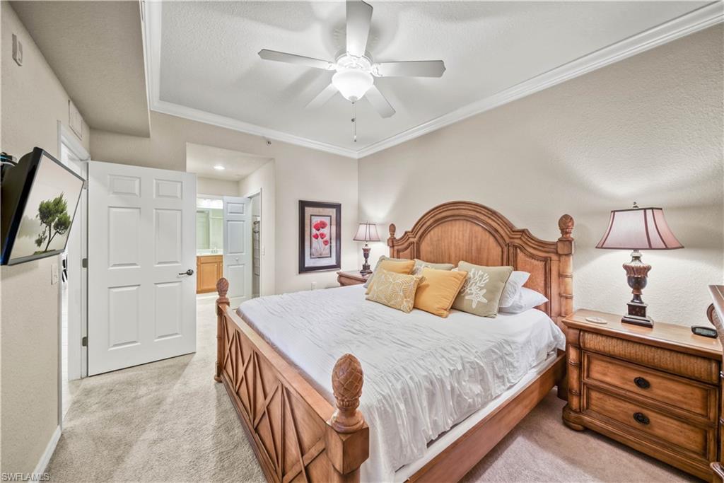 9715 Acqua Court, Unit 136 Naples, FL 34113 - Photo 13 of 24 a bedroom with a bed and a chandelier