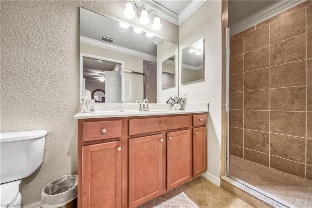 9715 Acqua Court, Unit 136 Naples, FL 34113 - Photo 17 of 24 a bathroom with a sink a toilet and shower