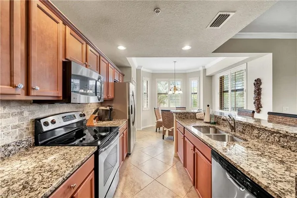 a kitchen with stainless steel appliances granite countertop a sink stove and refrigerator