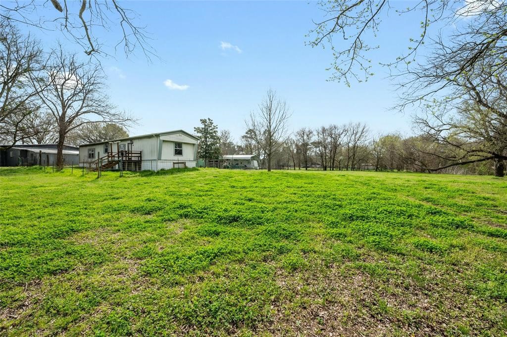 566 State Highway 95 Bastrop, TX 78602 - Photo 29 of 32 a view of a green field with trees in the background