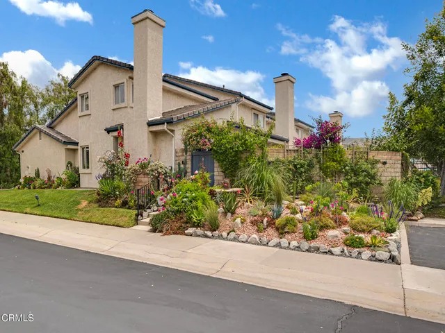 a front view of a house with a yard and potted plants