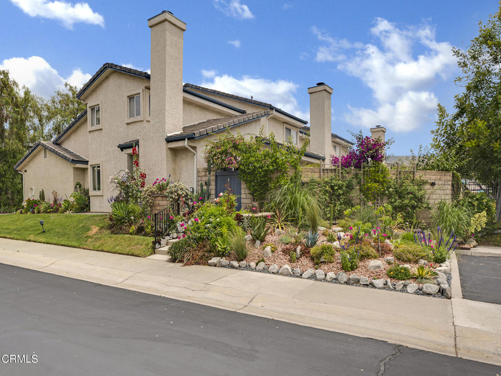 a front view of a house with a yard and potted plants
