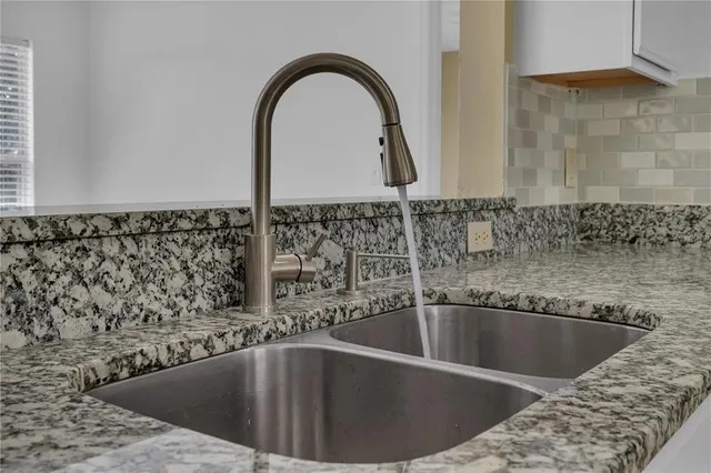 a kitchen with stainless steel appliances granite countertop a sink and a stove