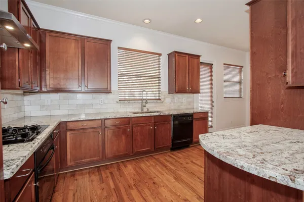 a kitchen with stainless steel appliances granite countertop wooden cabinets a sink and dishwasher