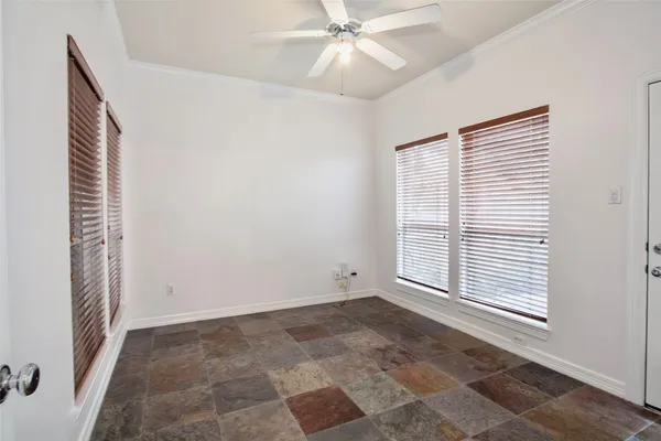 a view of an empty room with a window and a ceiling fan