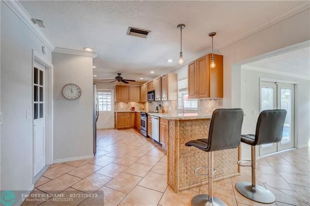 a kitchen with stainless steel appliances kitchen island granite countertop a refrigerator and a sink