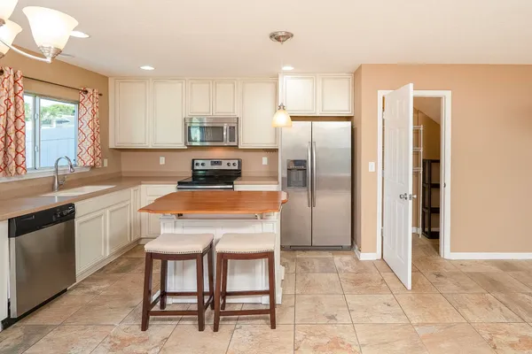 a kitchen with a refrigerator stove and white cabinets