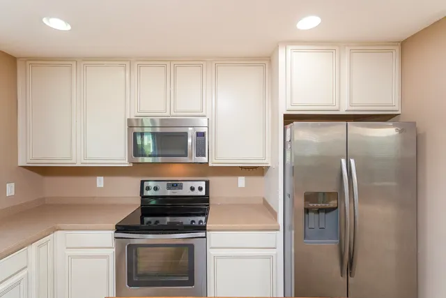 a kitchen with a sink cabinets appliances and a window