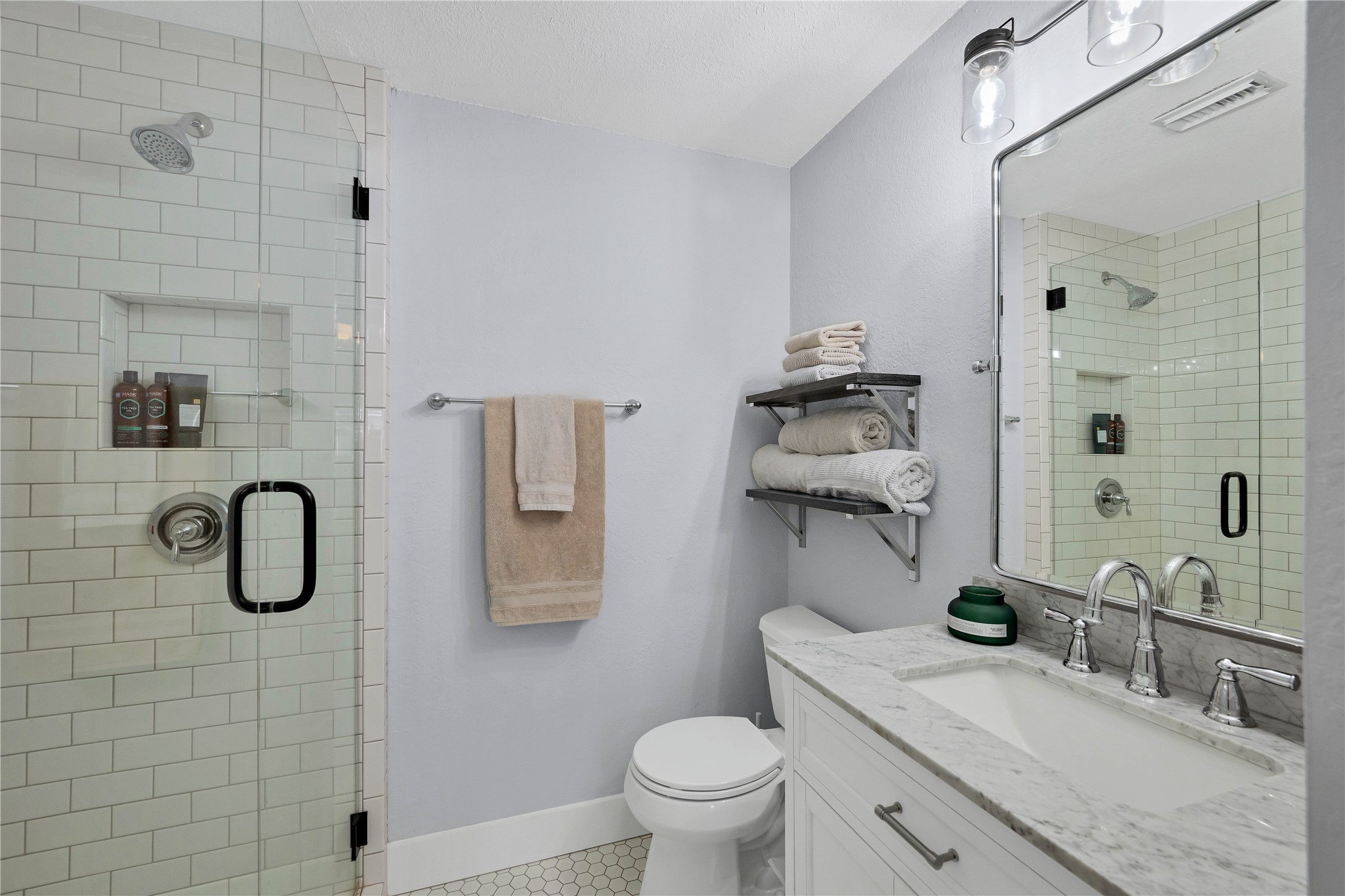 2605 Enfield Road, Unit 221 Austin, TX 78703 - Photo 19 of 30 Bathroom 2 was also updated with marble-top vanity, frameless glass shower with shampoo niche, bench seat and hexagon tile floor.