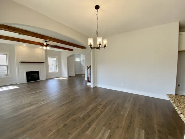 a view of a livingroom with wooden floor a fireplace and a window