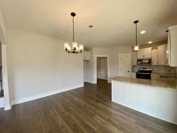 a view of a kitchen with a sink dishwasher a refrigerator and a wooden floor